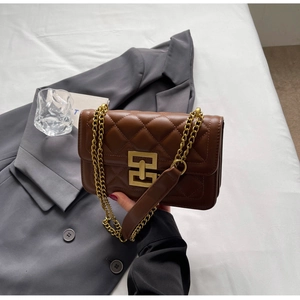Détail du sac bandoulière en cuir matelassé marron foncé avec chaîne dorée et fermoir