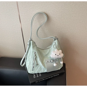 Detail of mint green nylon hobo bag with pleated texture and cloud plush charm