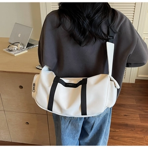 Vista dettagliata della borsa sportiva bianca con tracolla nera regolabile sulla modella
