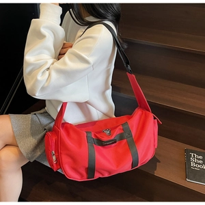 Dettaglio della borsa sportiva in tessuto oxford rosso con tracolla e tasca