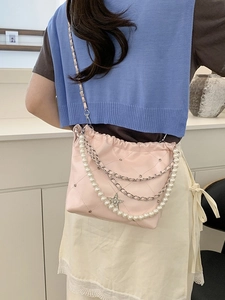 Sac seau matelassé rose avec chaîne en perles et pendentif étoile porté