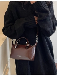 Minimalist dark brown leather pillow bag with shoulder strap and top handles for women