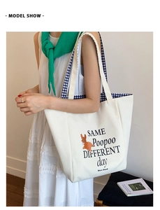 Detail of canvas tote bag with orange cartoon dog print and blue checkered lining