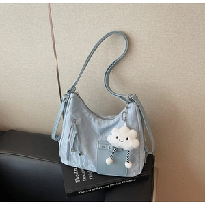 Close-up of light blue pleated nylon shoulder bag with a cute white cloud plush charm