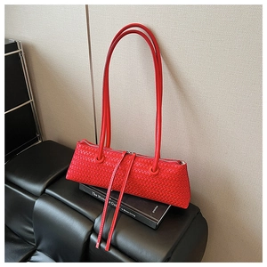 Detailed macro view of a red woven leather shoulder bag with long tassel zippers