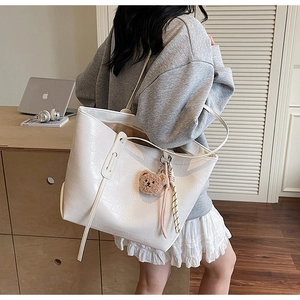 White croc-effect tote bag styled with a cute bear charm and silk scarf on a grey hoodie