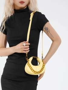 Mini yellow crescent shoulder bag with lychee texture and gold chain on a black dress model