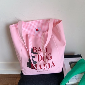 Detail of pink canvas tote bag showing checked inner lining and unique graphic print