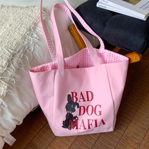 Close-up of pink canvas tote bag featuring Moon SharK branding and checkered lining detail