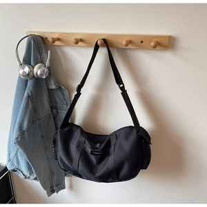 Dettaglio della borsa sportiva in nylon nero con doppi manici e tracolla regolabile