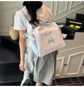 Detail der blauen Punkte-Tasche mit Moos Stuart Hasenstickerei und weißem Spitzenband