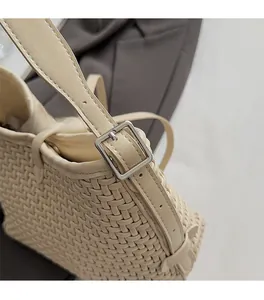 Dettaglio della borsa tote intrecciata beige con fibbia in metallo argento e texture