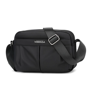 Close-up of black nylon crossbody bag featuring multiple zipper pockets and adjustable strap