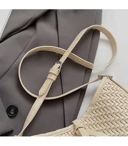 Dettaglio di borsa tote intrecciata beige con trama in pelle e fibbia regolabile