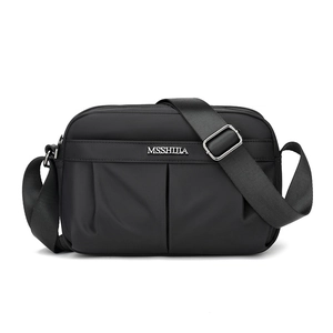 Detail of black crossbody bag featuring pleated front pocket and MSSHIJIA logo