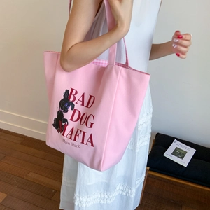Detail of pink canvas tote bag with black poodle print and checkered inner lining
