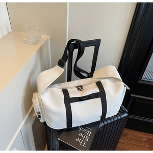 Vista ravvicinata della borsa da viaggio beige in tessuto oxford su una valigia