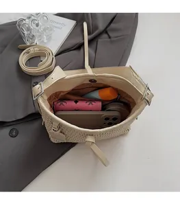 Vista interna della borsa a secchiello intrecciata beige con spazio per cellulare e portafoglio