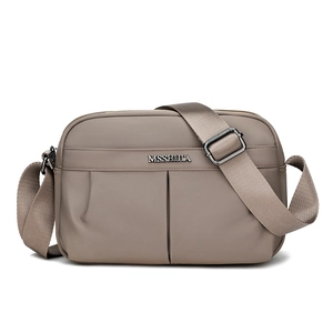 Macro detail of khaki nylon crossbody bag with metal logo and pleated texture