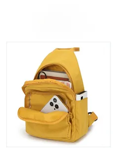 Detail view of mustard yellow nylon crossbody bag showing multiple pockets and storage capacity