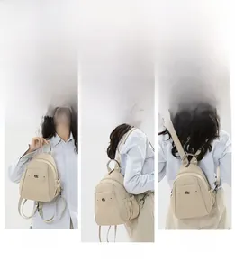 Detail showing beige Oxford backpack worn as handbag, shoulder bag and rucksack styles