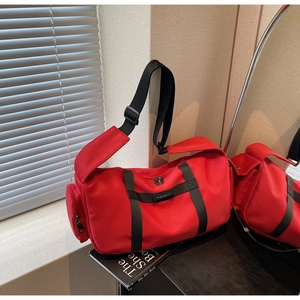 Dettaglio della borsa a tracolla in nylon oxford rosso con tasca laterale con cerniera