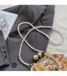 Close-up of crochet shell bag with 3D floral bear design and pearl chain strap