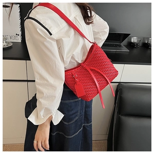 Dettaglio borsa hobo intrecciata rossa con tracolla regolabile e ciondolo laterale