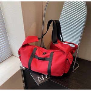 Dettaglio borsa sportiva rossa in tessuto Oxford con cinghie in nylon nero e zip metalliche