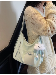 Mint green large capacity shoulder bag with cloud plush pendant shown on model
