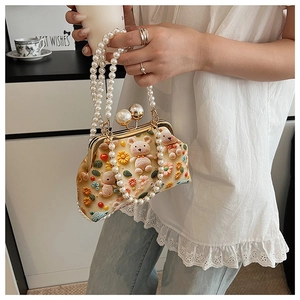 Detail of crochet bear bag featuring pearl handle and colorful floral 3D embroidery