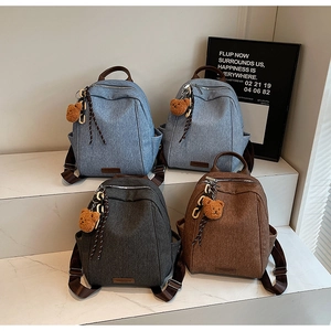 Detailed display of four colorful minimalist backpacks with cute plush bear pendants