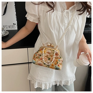 Detail of crossbody bag with floral bear embroidery and large pearl bead chain