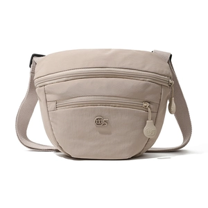 Detail view of the beige canvas saddle bag showing double zipper pockets and woven strap