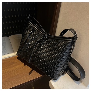 Detail showing the intricate black woven texture and matching strap of the tote bag