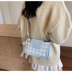Detail of light blue checkered crossbody bag with lace pearl bow and fashion logo