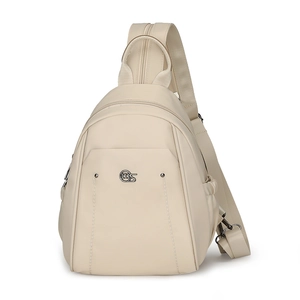 Detail of water-resistant off-white nylon chest bag with round metal logo and wide strap