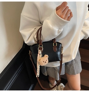Chic black matte bucket bag with cute plush bear and stylish woven ribbon details