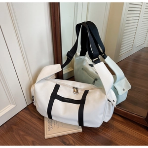 Dettaglio di una borsa sportiva in tessuto Oxford bianco con texture e tasca laterale