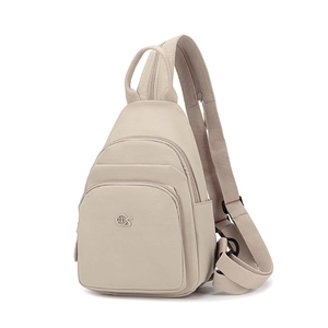 Detail of off-white nylon chest bag showing multi-pocket design and adjustable strap