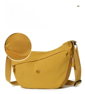 Detail view of yellow crescent canvas bag featuring custom lining and adjustable strap
