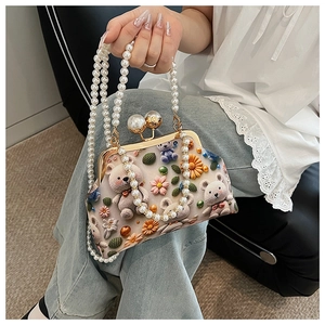 Detail of beaded handbag featuring 3D crochet bears, floral accents, and pearl straps