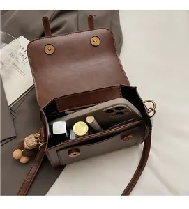 Detail view of brown vintage crossbody bag interior with dual magnetic buckles