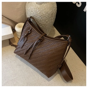 Detailed view of dark brown woven leather texture with silver hardware on shoulder bag
