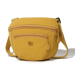 Detail view of mustard yellow nylon crossbody bag featuring double front zipper pockets