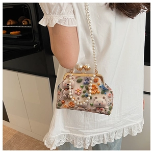 Detail of crossbody bag with pearl strap, 3D crochet bear and floral accents