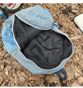 Internal compartment detail of blue denim patchwork backpack with black fabric lining