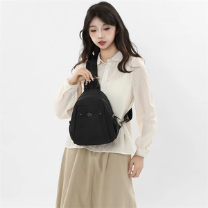 Detailed view of women's black waterproof oxford backpack on model for outdoor travel