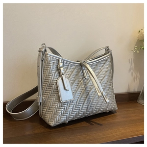Detailansicht der silbernen gewebten Handtasche mit Metallic-Finish und Boden-Nieten