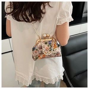 Mini shell bag with 3D floral bear design and pearl strap worn by model in back view